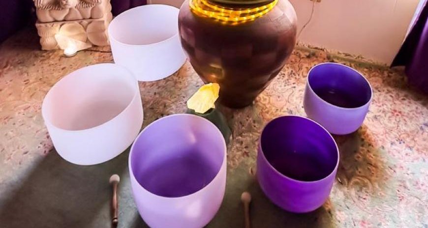 Crystal singing bowls in soft daylight on the studio floor, mallets resting beside them